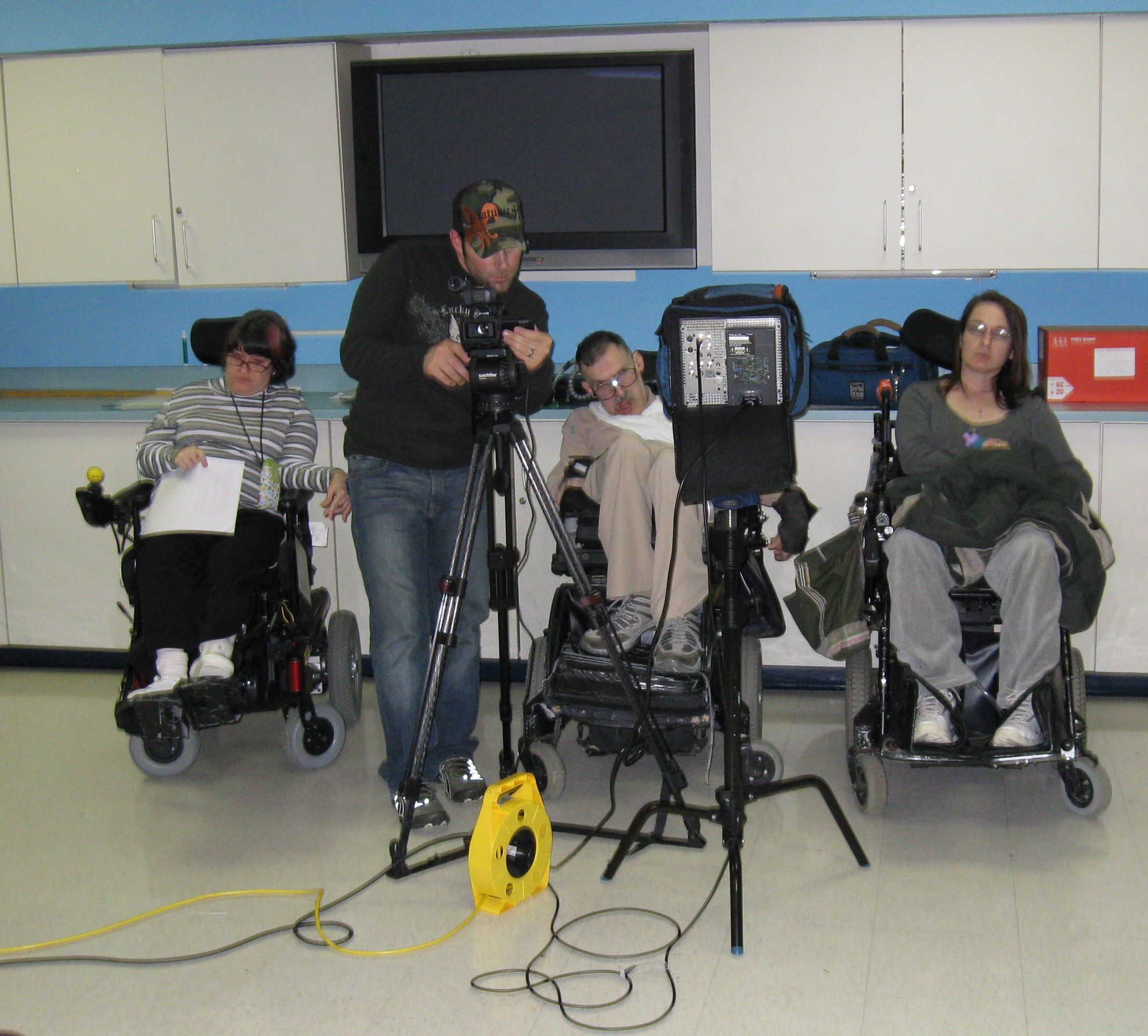 Film Director Chris Ambolino at camera flanked by three Inglis House residents in wheelchairs.