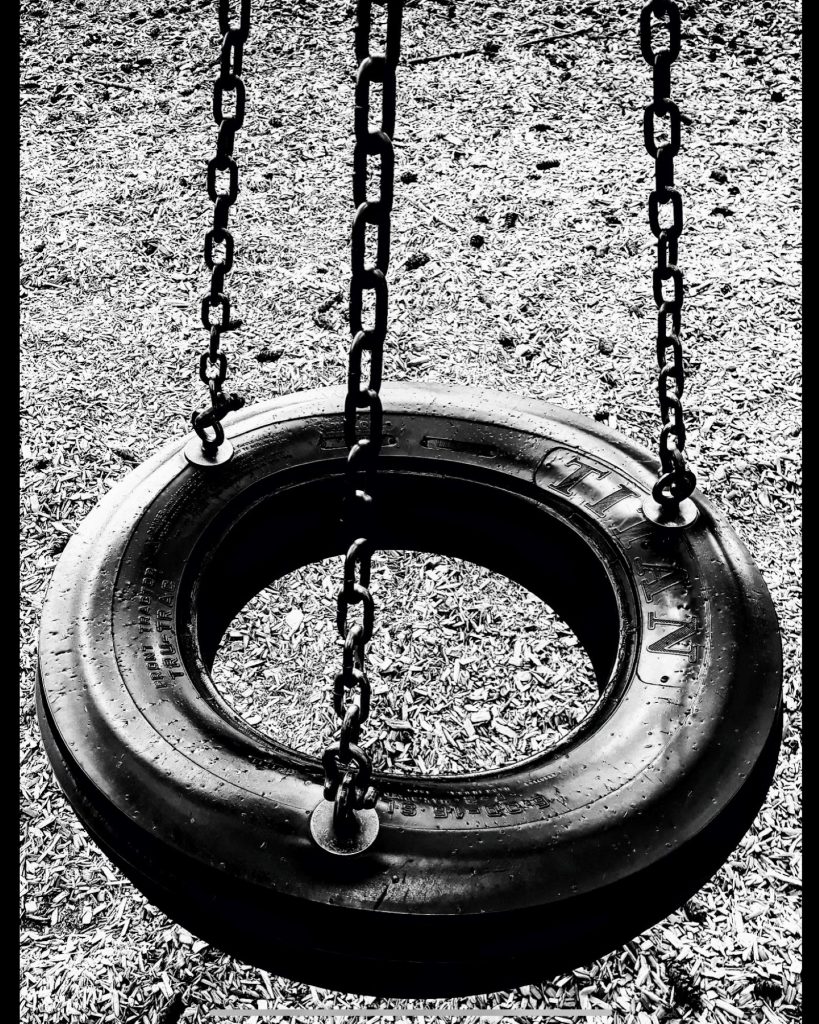 Digital BW Photo, 2021. Celebrating personal reinvention, re-purposing, and re-imagineering. The bottom half of the frame is full of the image of a tire-swing mounted on three chains which stretch to the top of the image