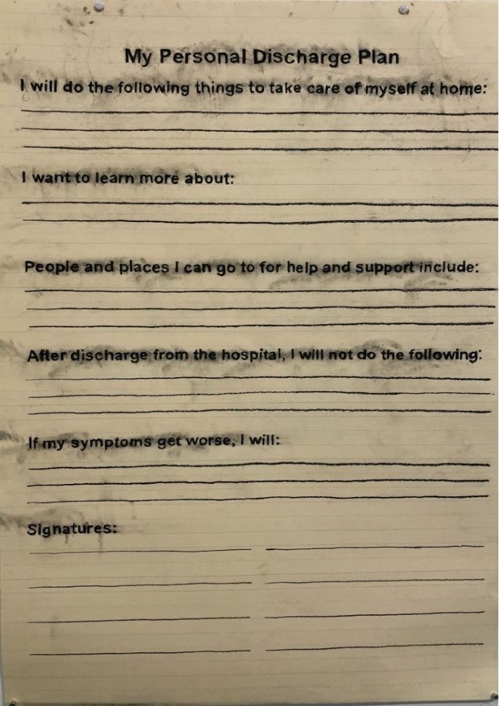 Charcoal drawing from series, “What I have learned (Fill in the Blank),” 2020, charcoal on lined paper, 36” x 24”. Text from a workbook given during hospitalization for a bipolar disorder manic episode. The headline is, “My Personal Discharge Plan.” Below it is text followed by lines to fill in the blanks after each sentence. “I will do the following to take care of myself at home…I want to learn more about…People and places I can go to for help and support include…After discharge from the hospital, I will not do the following…If symptoms get worse, I will…” At the bottom is the word “Signatures:” with the expectation that the person receiving care and the treatment team will sign it.
